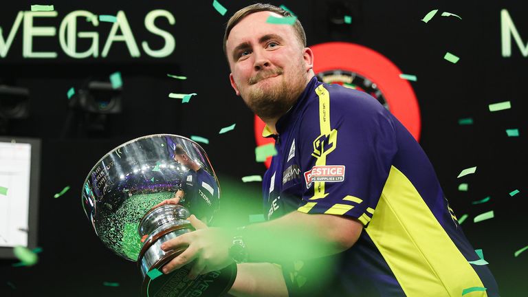 Luke Littler celebrates with the Eric Bristow Trophy after winning the Grand Slam of Darts (pic: PDC)