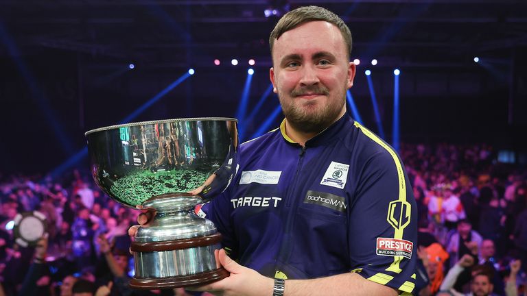 Luke Littler celebrates with the Eric Bristow Trophy after winning the Grand Slam of Darts (pic: PDC)