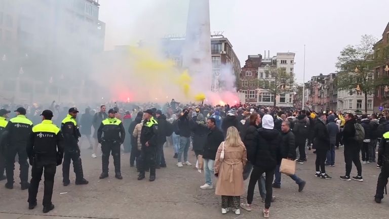 Police standing guard as Maccabi Tel Aviv supporters light flares at the Dam square