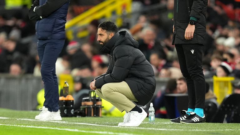 A crouching Ruben Amorim watches his Man Utd side at Old Trafford