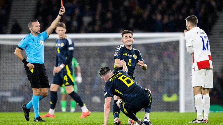 GLASGOW, SCOTLAND  - NOVEMBER 15: Referee Orel Grinfeeld (L) shows a red card to Croatia's Petar Sucic during the UEFA Nations League 2024/25 League A Group A1 match between Scotland and Croatia at Hampden Park, on November 15, 2024, in Glasgow, Scotland. (Photo by Alan Harvey / SNS Group)