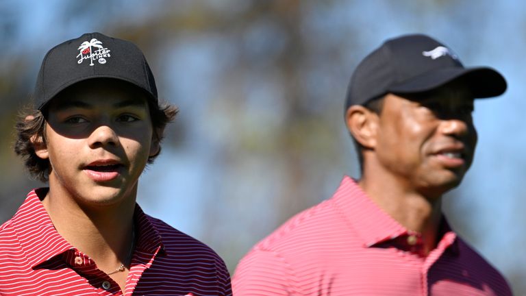 Charlie Woods, left, walks on the fourth fairway after hitting a hole-in-one alongside his father, Tiger