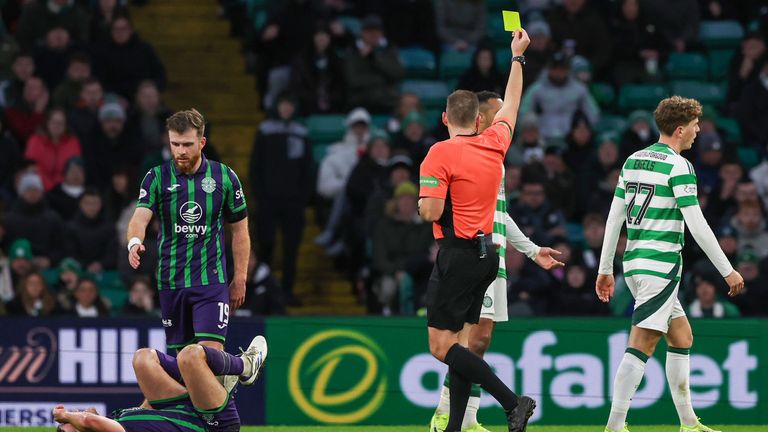 Referee Chris Graham shows a yellow card to Celtic's Arne Engels for a foul on Joe Newell 