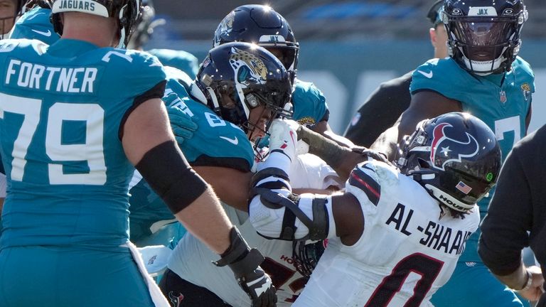 Players fight after Houston Texans linebacker Azeez Al-Shaair (0) hit Jacksonville Jaguars quarterback Trevor Lawrence with a late hit during the first half of an NFL football game Sunday, Dec. 1, 2024, in Jacksonville, Fla. (AP Photo/John Raoux)