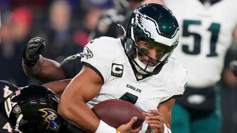 Philadelphia Eagles quarterback Jalen Hurts, right, is tackled by Baltimore Ravens safety Kyle Hamilton during the first half of an NFL football game, Sunday, Dec. 1, 2024, in Baltimore. (AP Photo/Stephanie Scarbrough)