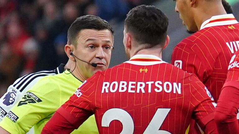 Referee Tony Harrington talks to Andy Robertson before showing the Liverpool defender a red card