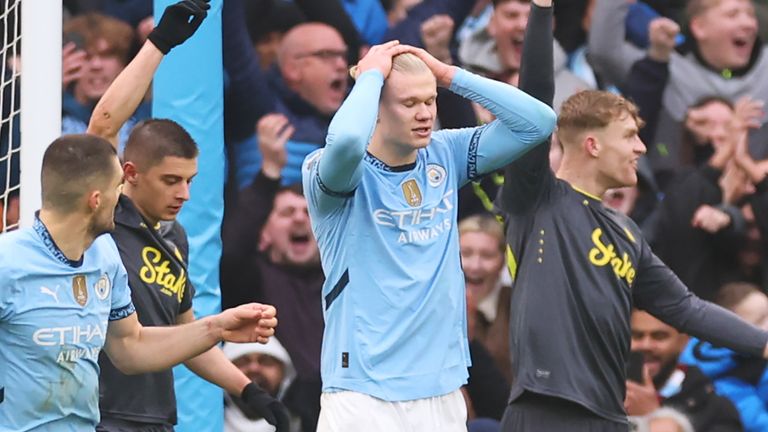 Erling Haaland holds his head in his hands after seeing his penalty saved by Jordan Pickford