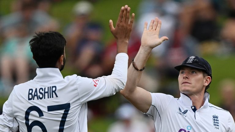 England bowler Shoaib Bashir, left, is congratulated by teammate Matthew Potts after taking the wicket of New Zealand's Glenn Phillips