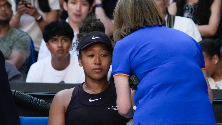 Naomi Osaka receives treatment from a trainer during her third-round match against Belinda Bencic