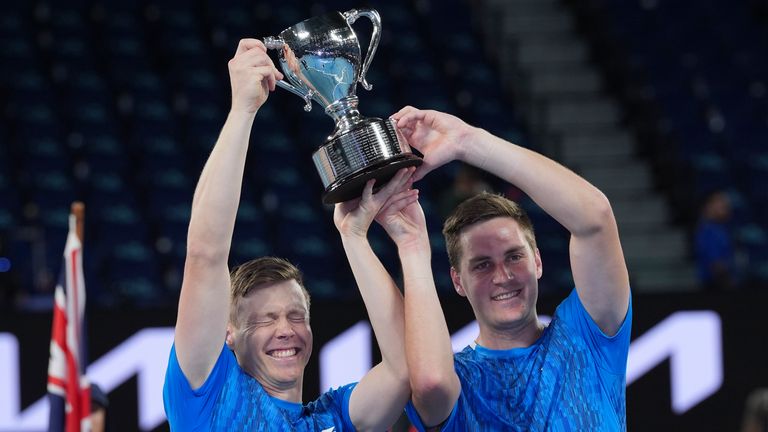 Harri Heliovaara, left, of Finland and Henry Patten of Britain celebrate as they hold their trophy after defeating Italy's Simone Bolelli and Andrea Vavassori in the men's doubles final at the Australian Open tennis championship in Melbourne, Australia, Sunday, Jan. 26, 2025. (AP Photo/Ng Han Guan)