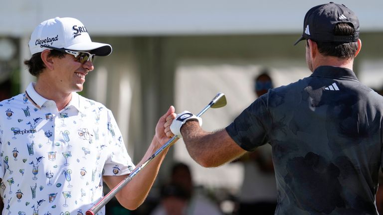 Nico Echavarria, kiri, dari Kolombia, menyapa Nick Taylor, dari Kanada, setelah Taylor melakukan pukulan di green ke-18 pada putaran final acara golf Sony Open, Minggu, 12 Januari 2025, di Waialae Country Club di Honolulu. (Foto AP/Matt York) 