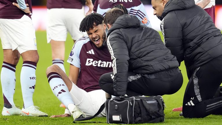 Tyrone Mings is being treated for a knee injury before leaving the field 