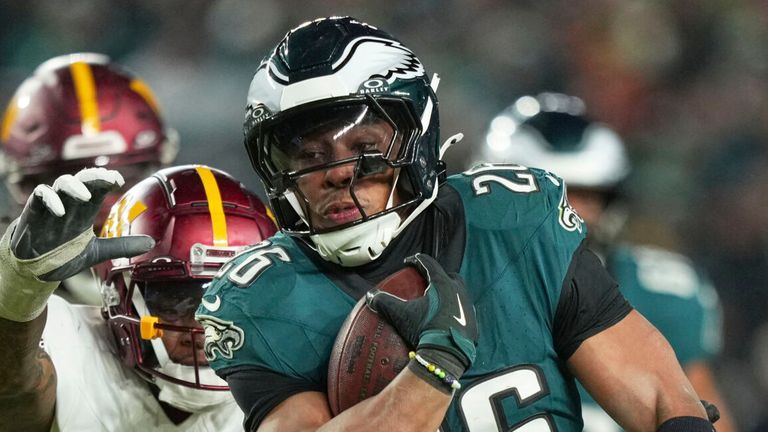 Philadelphia Eagles berlari kembali Saquon Barkley (26) berjalan untuk turun pertama ketika komandan Washington defensif Clellin Ferrell (99) bertahan selama paruh kedua pertandingan sepak bola NFC Championship NFL, Minggu, 26 Januari 2025, di Philadelphia. (Foto AP/Matt Slocum)