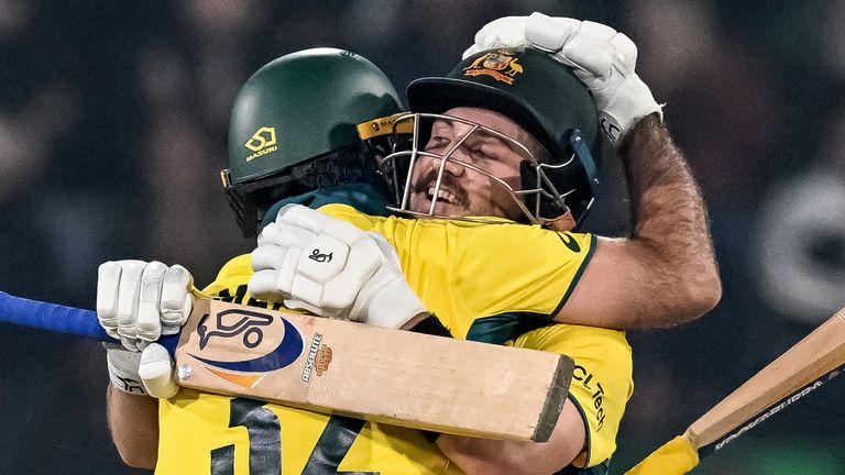 Australia's Josh Inglis (R) celebrates with teammate Maxwell after scoring a century (100 runs) during the ICC Champions Trophy one-day international (ODI) cricket match between Australia and England at the Gaddafi Stadium in Lahore on February 22, 2025. (Photo by Aamir QURESHI / AFP)