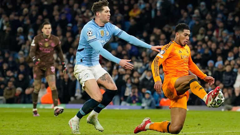 Real Madrid's Jude Bellingham, right, scores his sides third goal during the Champions League playoff first leg soccer match between Manchester City and Real Madrid at the Etihad Stadium in Manchester, England, Tuesday, Feb. 11, 2025. (AP Photo/Dave Thompson)