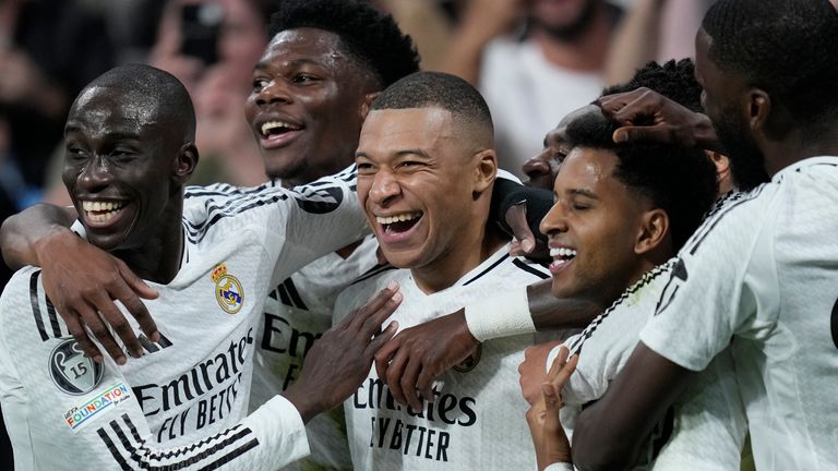 Real Madrid's Kylian Mbappe, center, celebrates after scoring his side's second goal during the Champions League playoff second leg soccer match between Real Madrid and Manchester City at the Santiago Bernabeu Stadium in Madrid, Spain, Wednesday, Feb. 19, 2025. (AP Photo/Bernat Armangue)