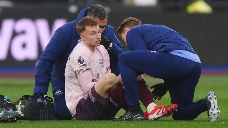 Brentford's Sepp van den Berg receives treatment before leaving the game with an injury