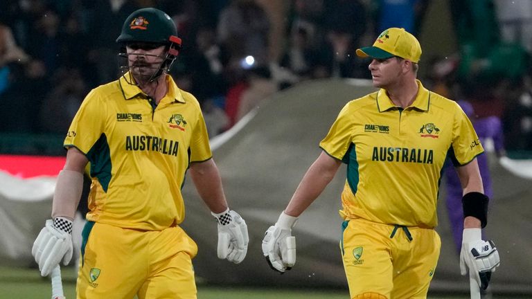 Steve Smith Australia, kanan, dan Travis Head berjalan di luar lapangan setelah hujan menghentikan permainan di Lahore