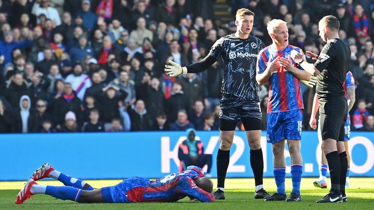 Jean-Philippe Mateta lies injured after a high challenge from Millwall's goalkeeper Liam Roberts