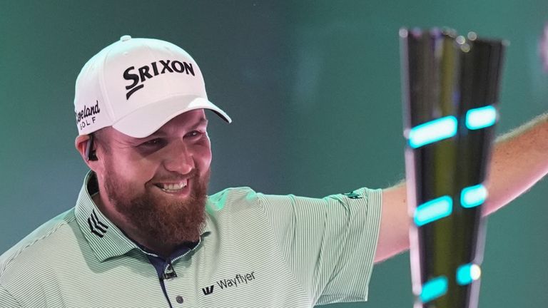 Shane Lowry of The Bay Golf Club waves as he walks onto the field of play past the league trophy, at the start of the inaugural match of the TMRW Golf League, against New York Golf Club, Tuesday, Jan. 7, 2025, in Palm Beach Gardens, Fla. TGL features six teams of four players competing against each other in a tech-infused arena the size of a football field. (AP Photo/Rebecca Blackwell)