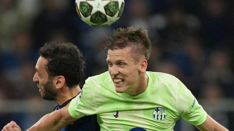 Inter Milan's Hakan Calhanoglu, left, and Barcelona's Dani Olmo jump for the ball during the Champions League semifinal second leg soccer match between Inter Milan and Barcelona at San Siro stadium in Milan , Italy, Tuesday, May 6, 2025. (AP Photo/Antonio Calanni)
