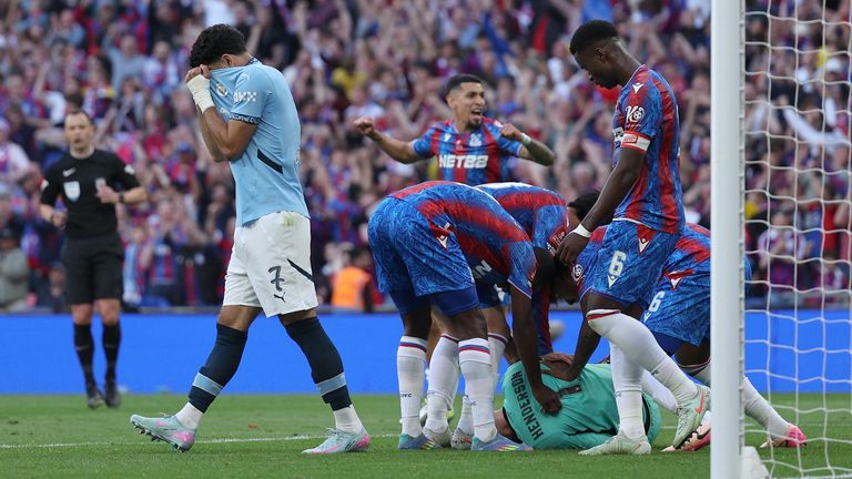 Dean Henderson is mobbed by his team-mates after saving Omar Marmoush's penalty