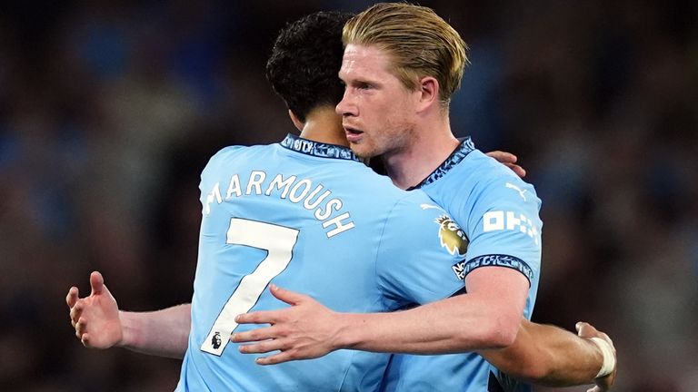 Kevin De Bruyne hugs team-mate Omar Marmoush as he leaves the pitch