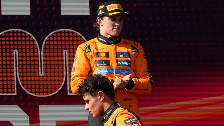 McLaren driver Lando Norris of Britain walks past McLaren driver Oscar Piastri of Australia on the podium after placing second at the Italian Emilia Romagna Formula One Grand Prix, at the Enzo and Dino Ferrari racetrack in Imola, Italy, Sunday, May 18, 2025. (AP Photo/Luca Bruno)