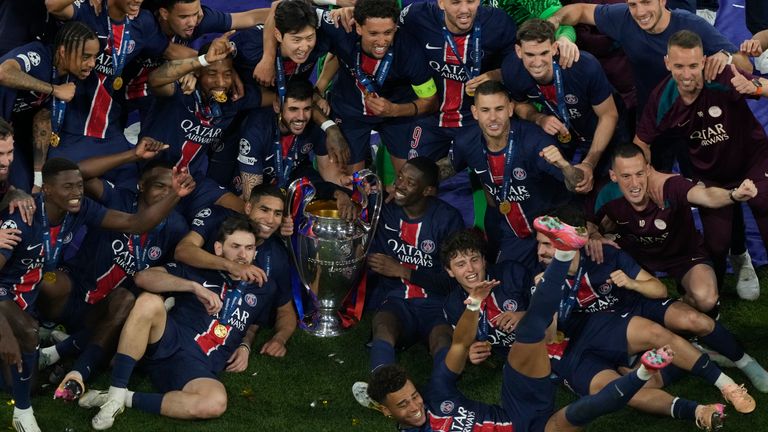 Players of PSG pose with the trophy after winning the Champions League tournament at the Allianz Arena in Munich, Germany, Saturday, May 31, 2025. (AP Photo/Michael Probst)