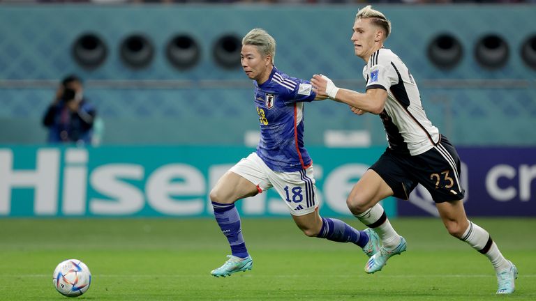 Takuma Asano of Japan, Nico Schlotterbeck of Germany during the World Cup match between Germany v Japan at the Khalifa International Stadium on November 23, 2022 in Doha Qatar