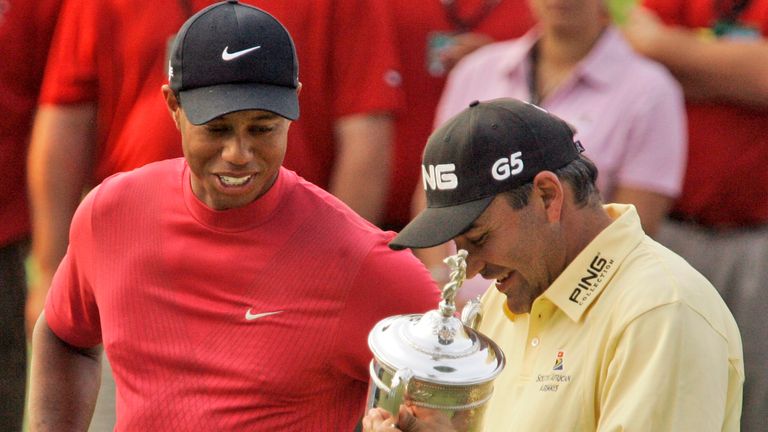 Tiger Woods, left, looks Angel Cabrera as Cabrera holds the trophy after Cabrera won the 107th U.S. Open Golf Championship at the Oakmont Country Club in Oakmont, Pa., Sunday, June 17, 2007. (AP Photo/Gene J. Puskar)
