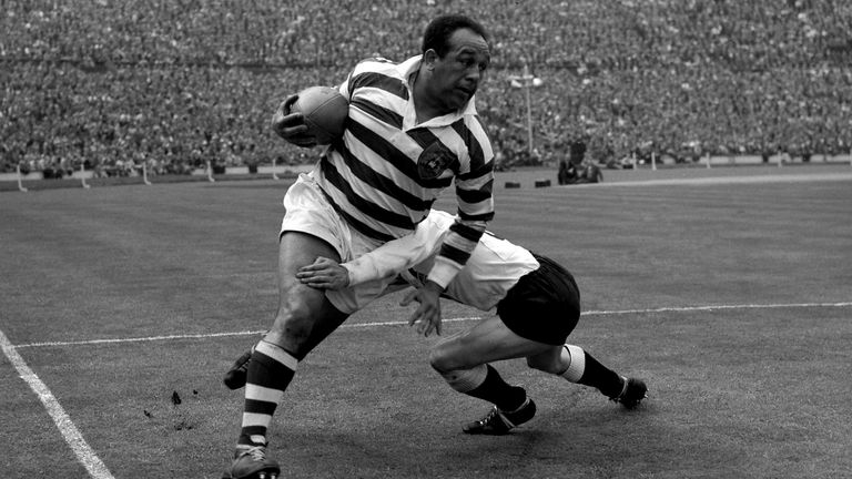 Legendary rugby league star Billy Boston (Wigan) bursts through despite a tackle by I. Watts (Hull) during the Rugby League Challenge Cup Fi