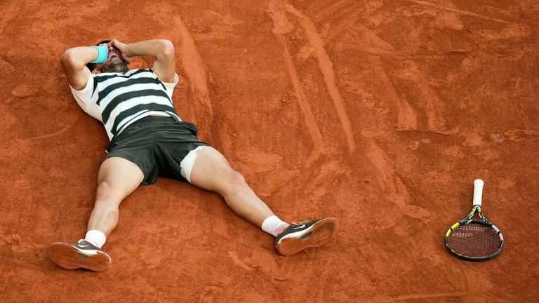 Carlos Alcaraz drops to the clay after sealing  a stunning fightback win against Jannik Sinner in the French Open final