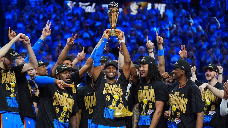 Oklahoma City Thunder guard Shai Gilgeous-Alexander, center, holds up the MVP trophy as he celebrates with his team after they won the NBA b