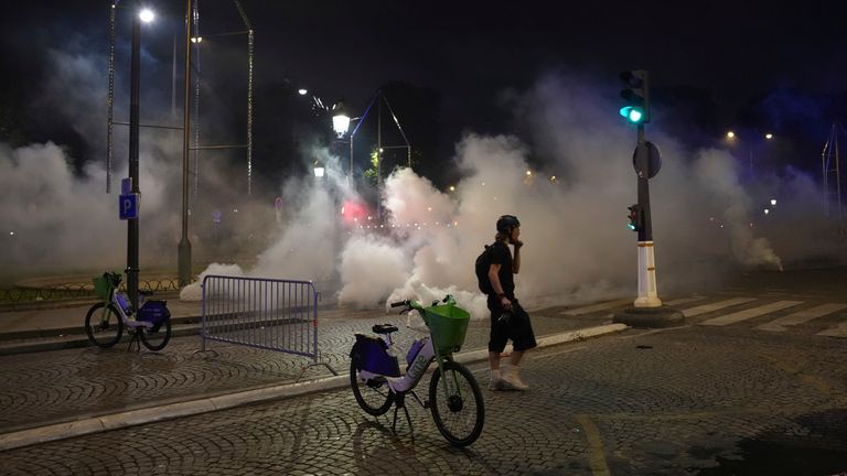 A man walks tear gas during the events that took place after the Champions League