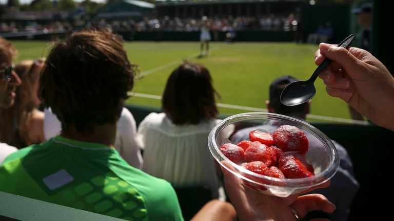 A spectator eating strawberries and cream during day one of the Wimbledon Championships at the All England Lawn Tennis and Croquet Club, Wim