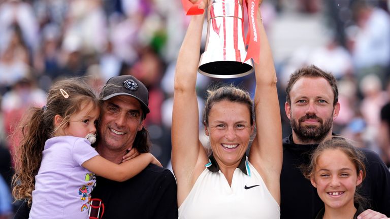 Tatjana Maria celebrates with the trophy alongside her family after defeating Amanda Anisimova