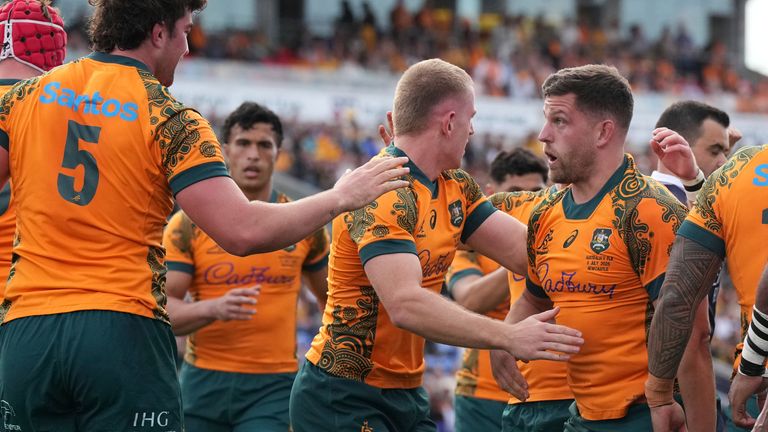 Australia's David Porecki, right, is congratulated by teammates after scoring his team's first try against Fiji during their rugby union international match in Newcastle, Australia, Sunday, July 6, 2025. (AP Photo/Mark Baker)