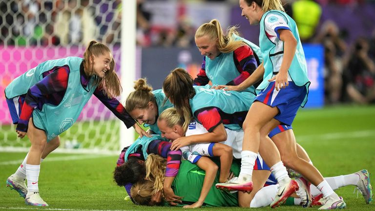 England players dive on Hannah Hampton after the goalkeeper helped the Lionesses to a shootout victory over Sweden at Euro 2025