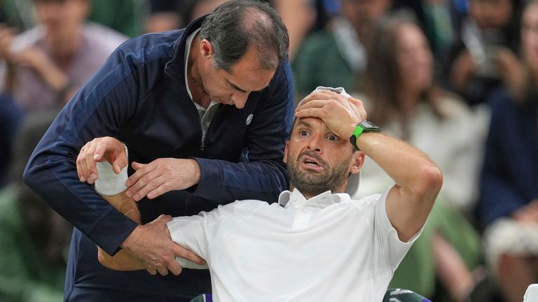 Bulgaria's Grigor Dimitrov gets treatment after he went down with an injury which forced him to retire injured from a fourth round men's sin