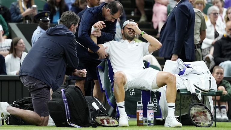 Grigor Dimitrov grimaces after suffering an injury in his match against Jannik Sinner at Wimbledon on July 7, 2025