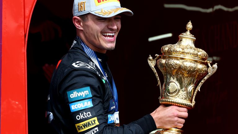 Lando Norris celebrates with the British GP winner's trophy