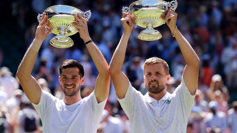 Julian Cash (left) and Lloyd Glasspool hold their double Wimbledon trophies at altitude