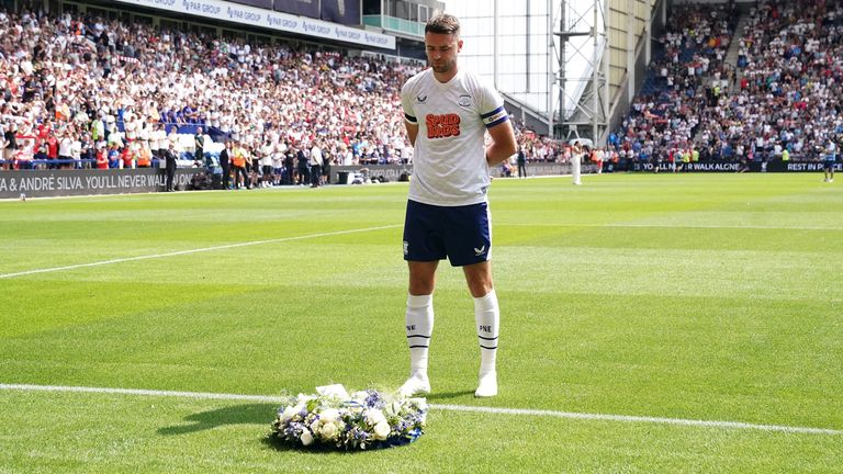 Preston captain Ben Whiteman poses a crown in front of Liverpool fans in honor of Diogo Jota