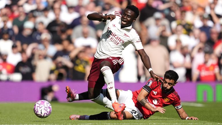 Man Utd Captain Bruno Fernandes (right) defies the winger Arsenal Bukayo Saka