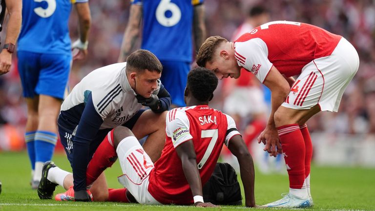 Arsenal's Bukayo Saka is treated by medical staff after going down injured in the match against Leeds