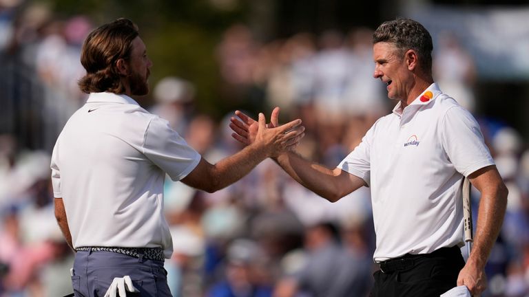 Tommy Fleetwood, left, of England, shakes hands with Justin Rose, of England, on the 18th green during the final round of the St. Jude Championship golf tournament Sunday, Aug. 10, 2025, in Memphis, Tenn. (AP Photo/George Walker IV)