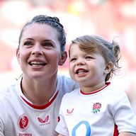 England lock Abbie Ward sits with her daughter, Hallie, on the pitch following semi-final victory in Women's Rugby World Cup