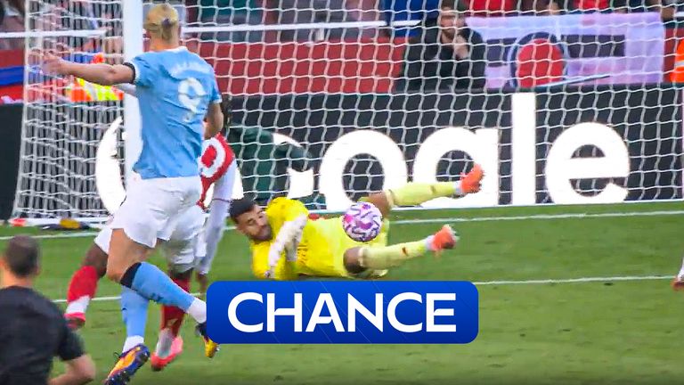 Man City's Erling Haaland takes a shot but David Raya saves for Arsenal.