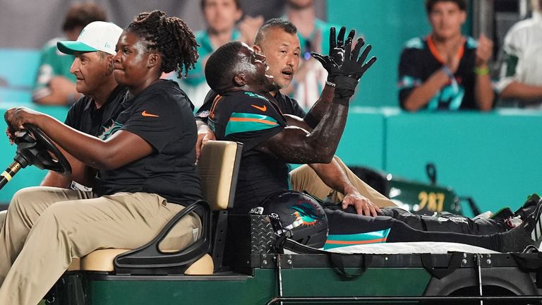 Miami Dolphins wide receiver Tyreek Hill, right front, puts his arms up as he is carted off the field after suffering a knee injury